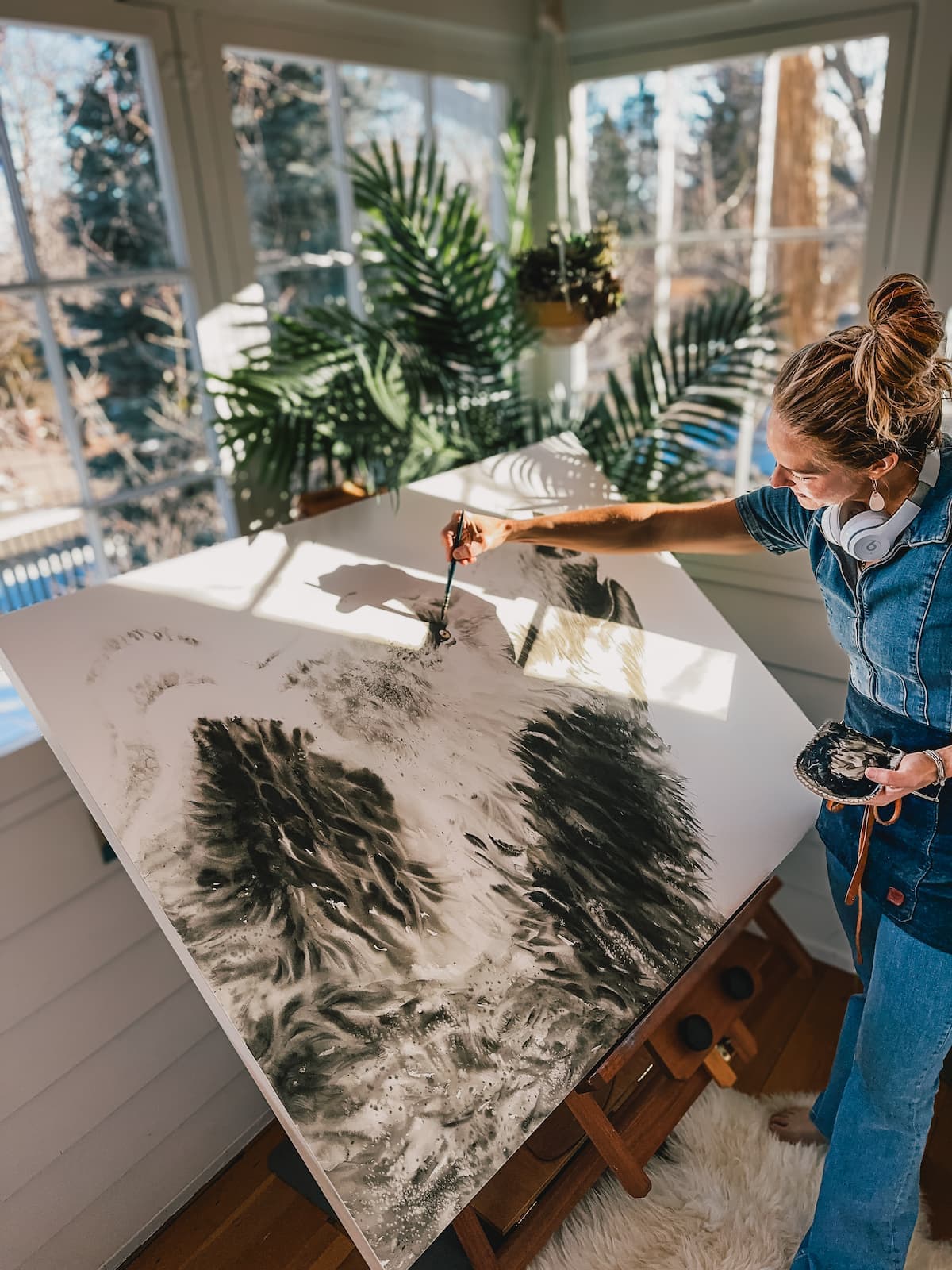 Shayna painting a bear on an easel